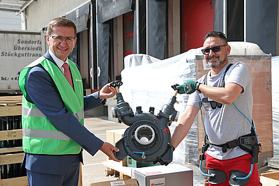 v.l.: Wirtschafts-Landesrat Markus Achleitner mit Rosenbauer-Mitarbeiter Elias Rashid, der demonstrierte, wie sich ein Exoskelett in der Praxis einsetzen lässt. ©Land OÖ/Kauder